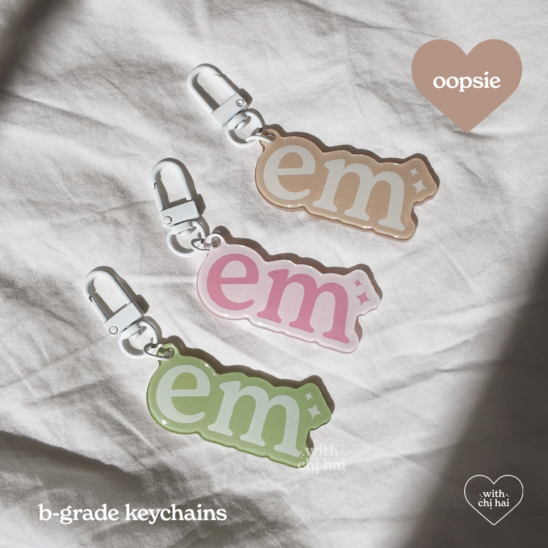 OOPSIE: em - acrylic keychain (discounted)
